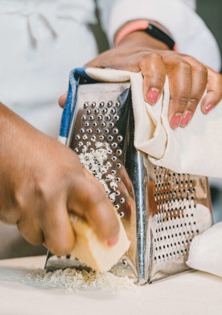 Une journée dans la vie d’un étudiante en cuisine en Italie 9 Détail du râpage du fromage lors d'un cours de cuisine professionnelle à Florence